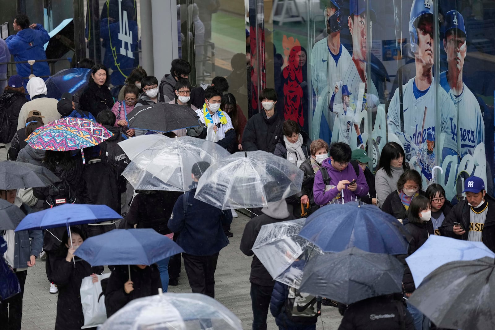 Baseball fans wait in line to get into an MLB souvenir store before the Tokyo Series exhibition games with the Los Angeles Dodgers, the Chicago Cubs, the Yomiuri Giants and the Hanshin Tigers at Tokyo Dome in Tokyo, Sunday, March 16, 2025. (AP Photo/Hiro Komae)