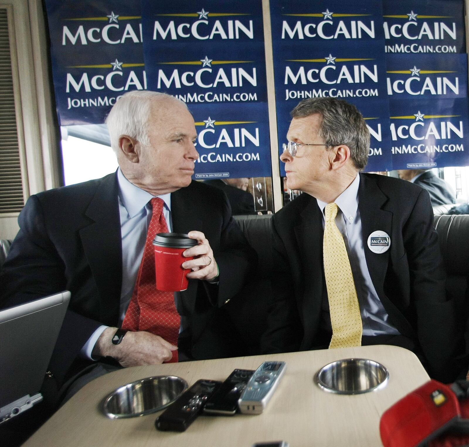 Republican presidential hopeful, Sen. John McCain, R-Ariz., left, and former Ohio Sen. Mike DeWine, R-Ohio, right, talk with reporters aboard McCain’s ‘Straight Talk Express’ campaign bus, en route from Columbus, Ohio to Yellow Springs, Ohio, Wednesday, Feb. 20, 2008. (AP Photo/Gerald Herbert)