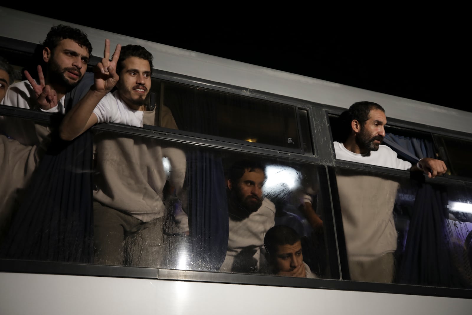 Freed Palestinian prisoners flash V-signs as they arrive in the Gaza Strip after being released from an Israeli prison following a ceasefire agreement between Hamas and Israel in Khan Younis, Gaza Strip, Thursday, Feb. 27, 2025. (AP Photo/Jehad Alshrafi)