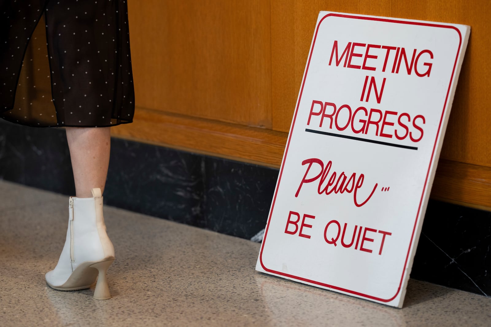 A person walks by a sign for a meeting in progress at the Oregon state Capitol on Wednesday, Dec. 11, 2024, in Salem, Ore. (AP Photo/Jenny Kane)