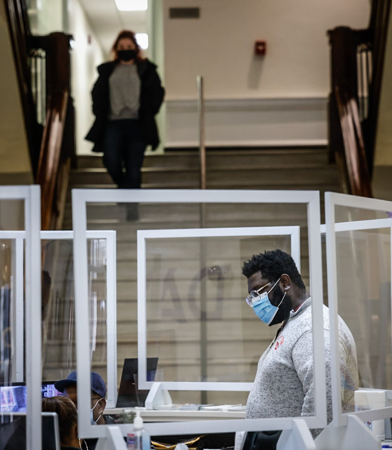 City of Dayton legislative aid, Jeffery Adams talks with security at city hall Friday January 6, 2023. The city of Dayton is requiring all employees to wear masks at work due to elevated local COVID levels. JIM NOELKER/STAFF