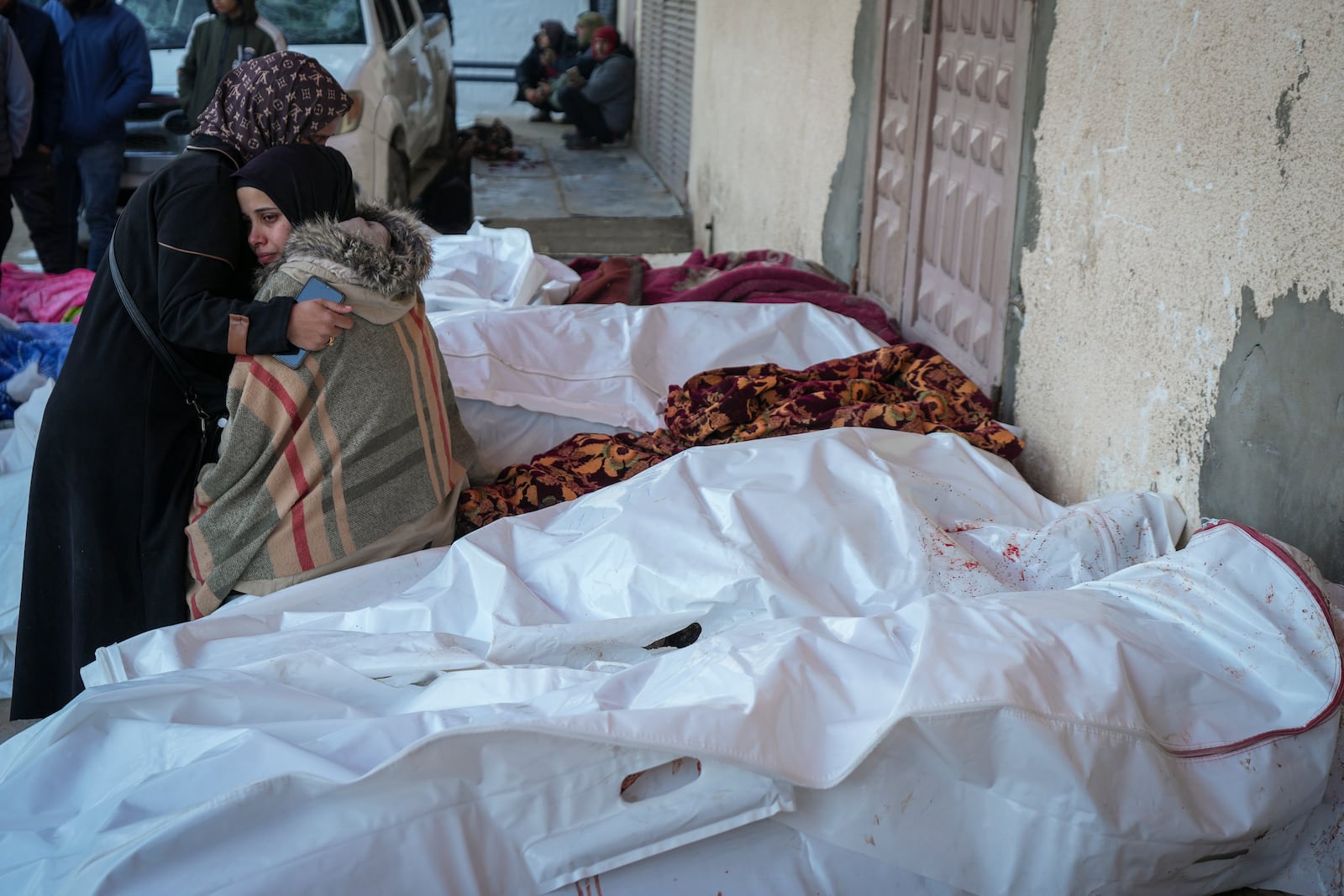 Relatives mourn over the bodies of victims of overnight Israeli army strikes at multiple locations in central Gaza Strip, at Al-Aqsa Martyrs Hospital in Deir al-Balah, Friday, Jan. 3, 2025. According to Al-Aqsa Martyrs Hospital, 30 people, including 10 women and 7 children, were killed in several attacks overnight in central Gaza. (AP Photo/Abdel Kareem Hana)