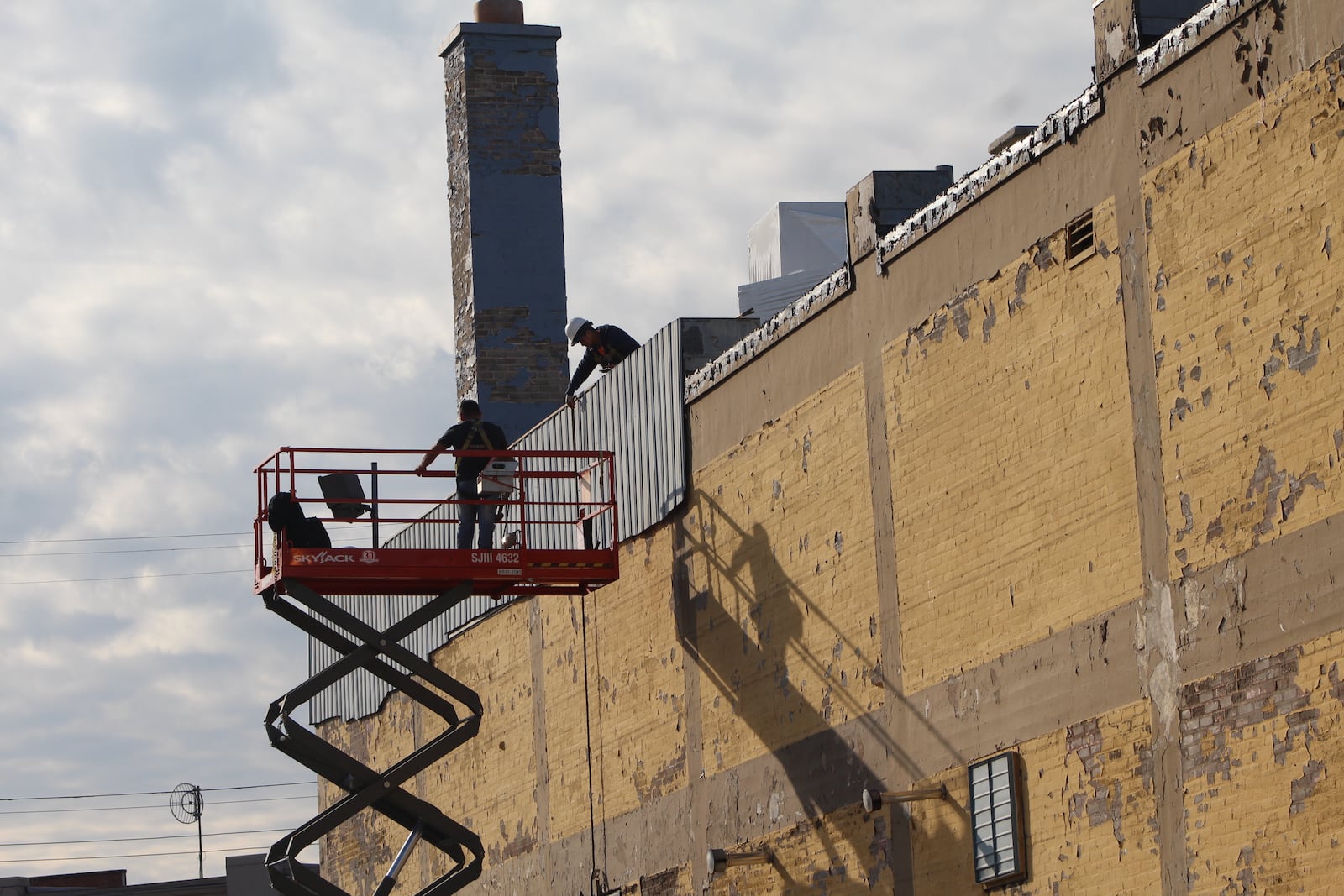 Crews work on the exterior of a building along Wayne Avenue in the Oregon District on Friday. CORNELIUS FROLIK / STAFF