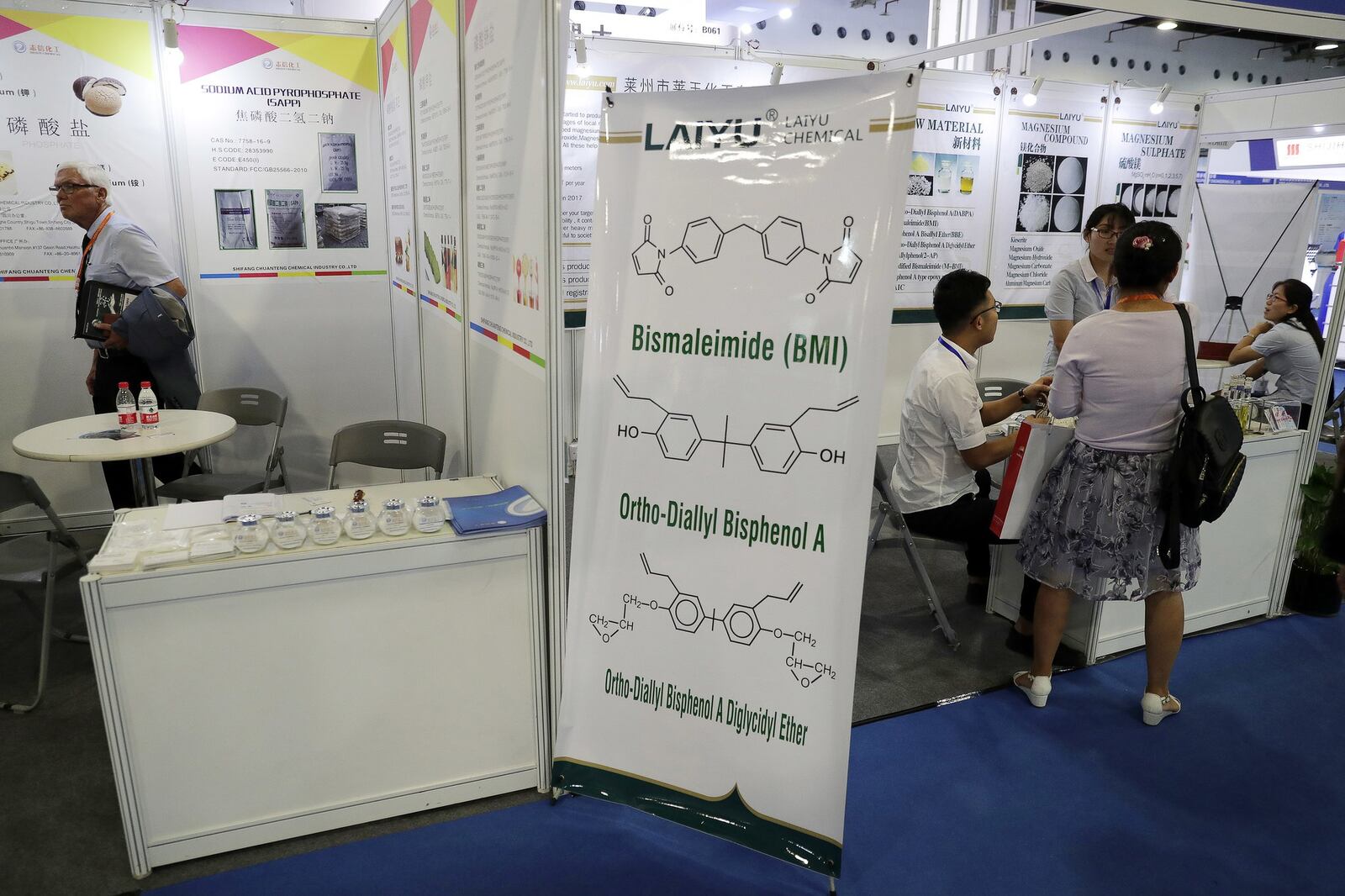 In this Wednesday, Sept. 21, 2016, photo, a foreign visitor tours a booths during the China International Chemical Industry Fair in Shanghai, China. For a few thousand dollars, it’s easy to find Chinese companies that offer to export the powerful chemical carfentanil, which has been killing unsuspecting drug users and is so lethal it presents a potential terrorism threat, an Associated Press investigation has found. (AP Photo/Andy Wong)