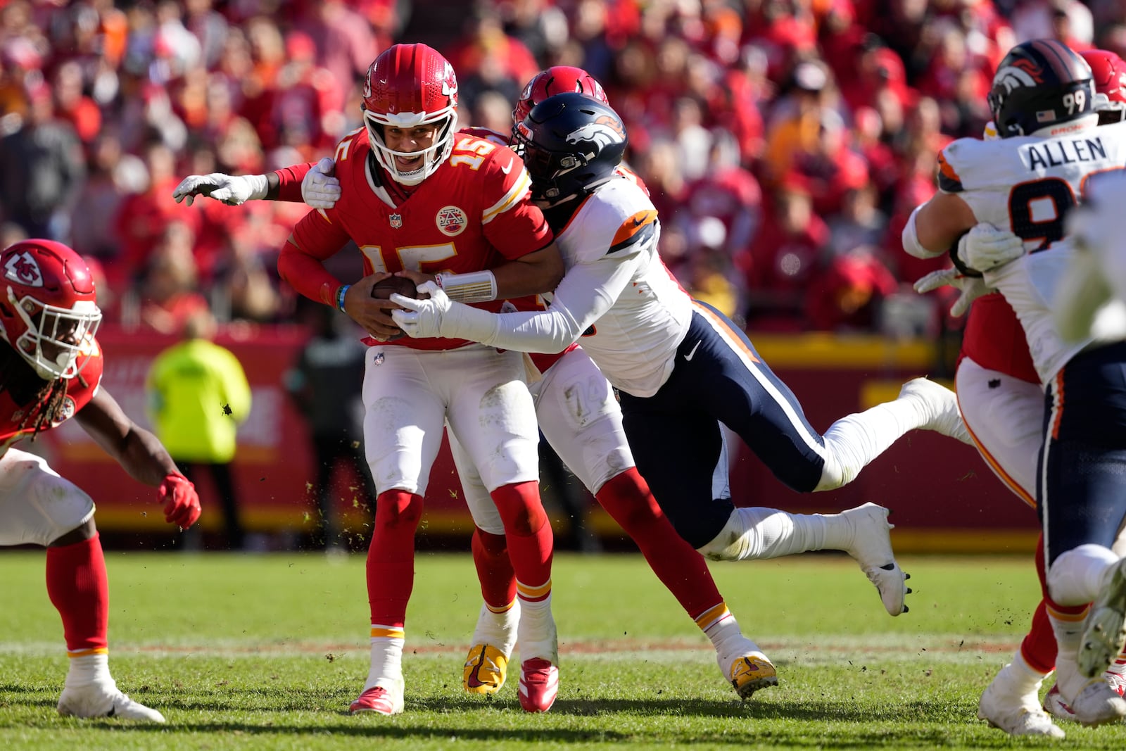 Kansas City Chiefs quarterback Patrick Mahomes (15) is stopped by Denver Broncos outside linebacker Jonathon Cooper, right, during the first half of an NFL football game Sunday, Nov. 10, 2024, in Kansas City, Mo. (AP Photo/Ed Zurga)