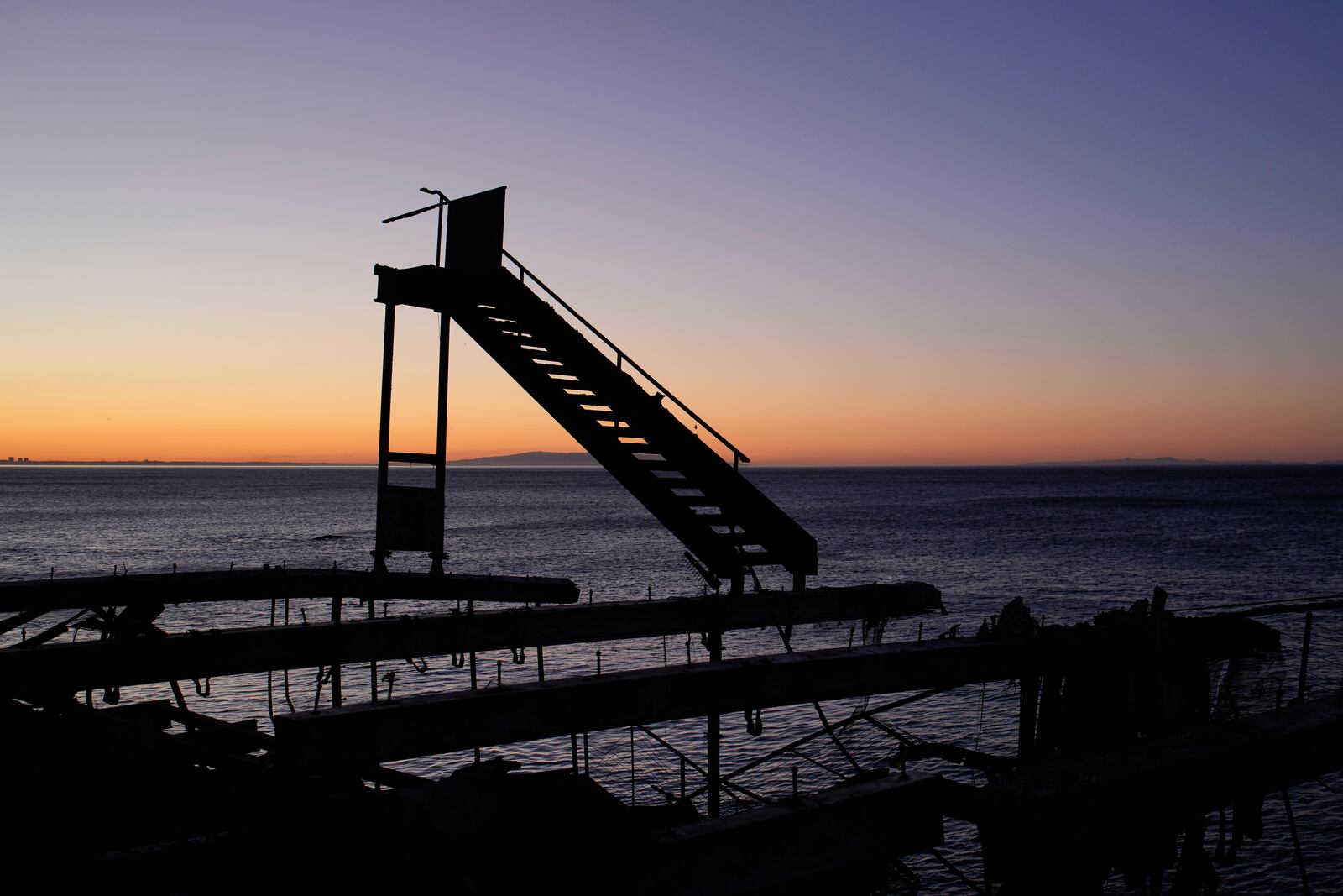 The sun rises behind a fire-ravaged beachfront property in the aftermath of the Palisades Fire Monday, Jan. 13, 2025 in Malibu, Calif. (AP Photo/John Locher)