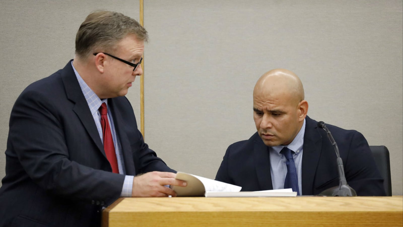 Dallas police Cpl. Martin Rivera, right, looks at records of his texts and Snapchats with ex-cop Amber Guyger during Guyger's murder trial. Guyger, 31, was convicted and sentenced Wednesday, Oct. 2, 2019, to 10 years for killing Botham Jean.