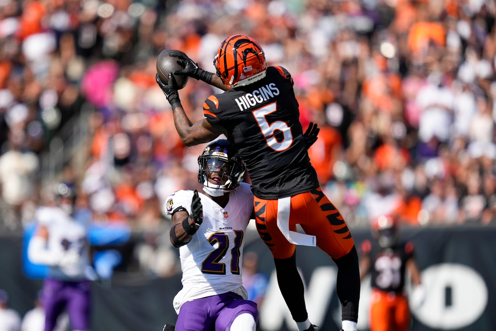 Baltimore Ravens cornerback Brandon Stephens (21) breaks up a pass intended for Cincinnati Bengals wide receiver Tee Higgins (5) during the first half of an NFL football game, Sunday, Oct. 6, 2024, in Cincinnati. (AP Photo/Carolyn Kaster)