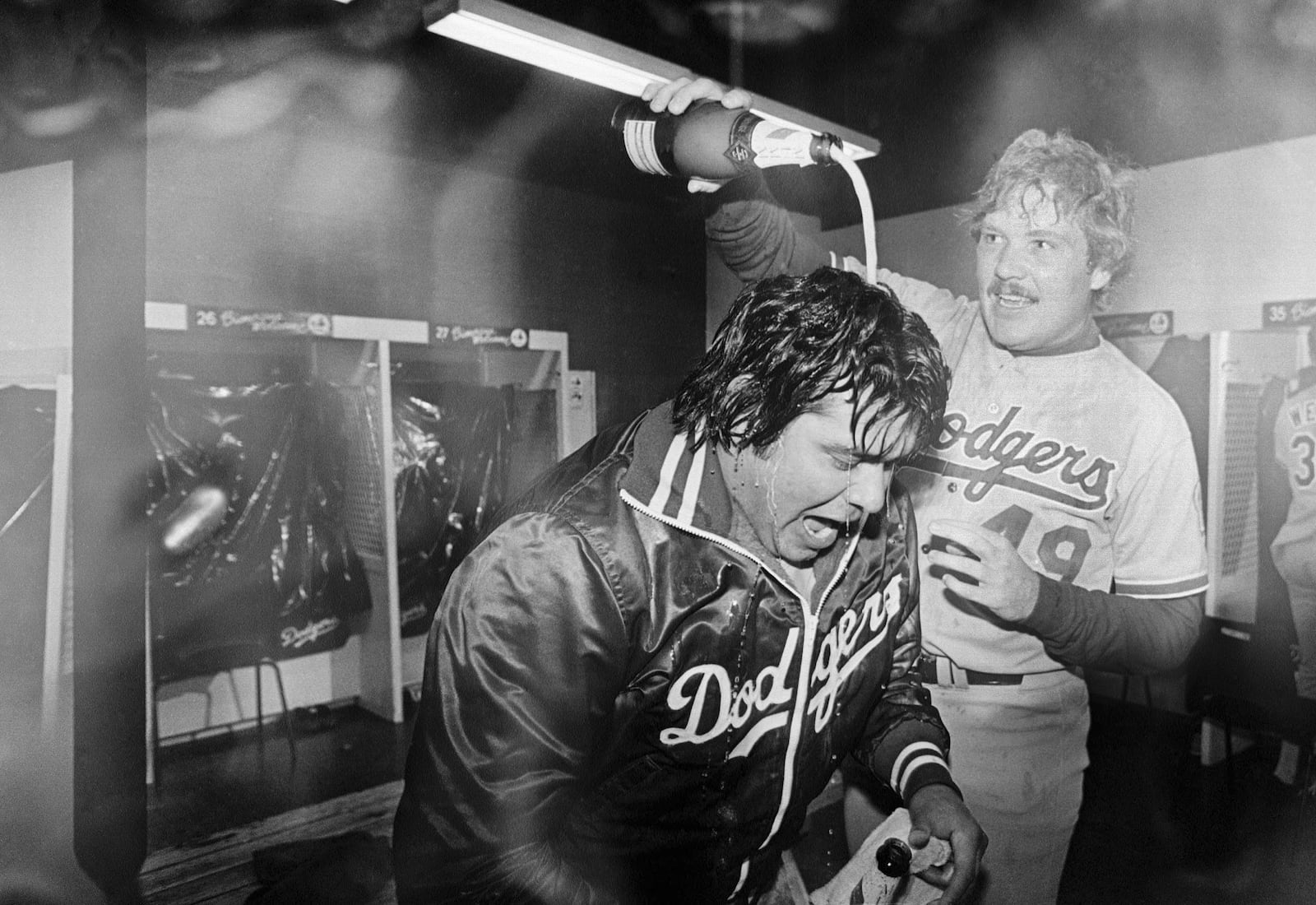 FILE - Los Angeles Dodgers pitcher Fernando Valenzuela is doused with champagne by teammate Tom Niedenfuer after the Dodgers won the National League title over the Expos, Oct. 20, 1981, in Montreal. Fernando Valenzuela, the Mexican-born phenom for the Los Angeles Dodgers who inspired “Fernandomania” while winning the NL Cy Young Award and Rookie of the Year in 1981, has died Tuesday, Oct. 22, 2024.(AP Photo/MacAlpine, File)