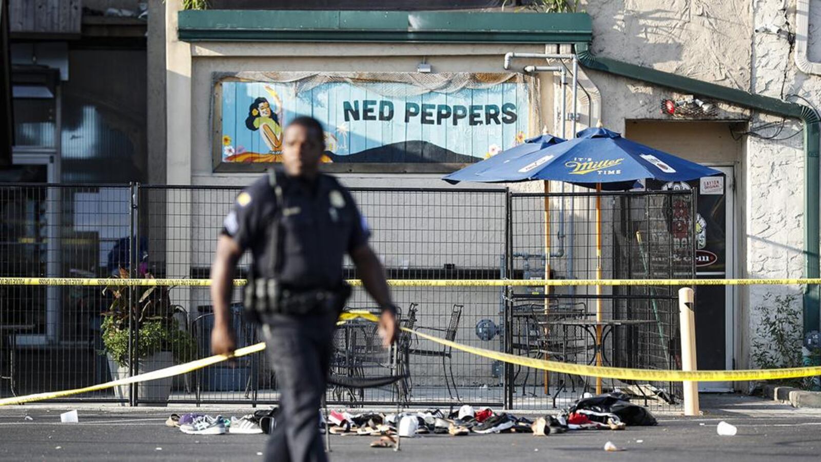 A Dayton officer walks near Ned Peppers the morning after nine people were killed and dozens injured when Connor Betts, opened fire on Aug. 4, 2019 in the Oregon District. Betts, 24, of Bellbrook, was later shot to death by police.