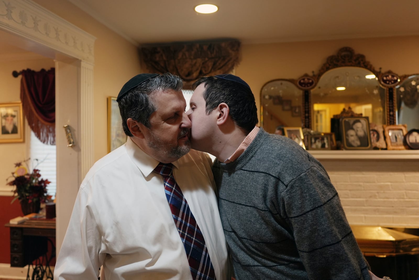 Dov Marcus, right, kisses his father, Robert Marcus, in Teaneck, N.J., on Friday, Dec. 20, 2024. (AP Photo/Luis Andres Henao)