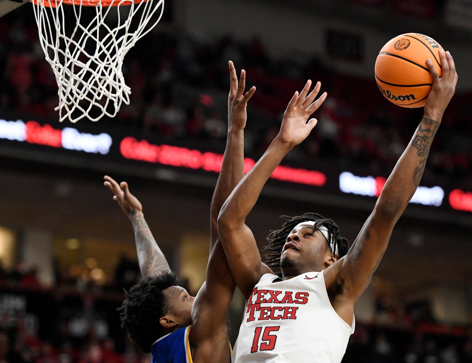 Texas Tech forward JT Toppin (15) goes for a shot as West Virginia forward Amani Hansberry (13) defends during the second half of an NCAA college basketball game, Saturday, Feb. 22, 2025, in Lubbock, Texas. (AP Photo/Annie Rice)