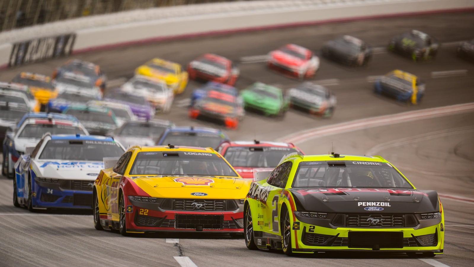 Austin Cindric (2) moves on the track with Joey Logano (22) closing during a NASCAR Cup Series auto race, Sunday, Feb. 23, 2025, in Hampton, Ga. (AP Photo/Mike Stewart)