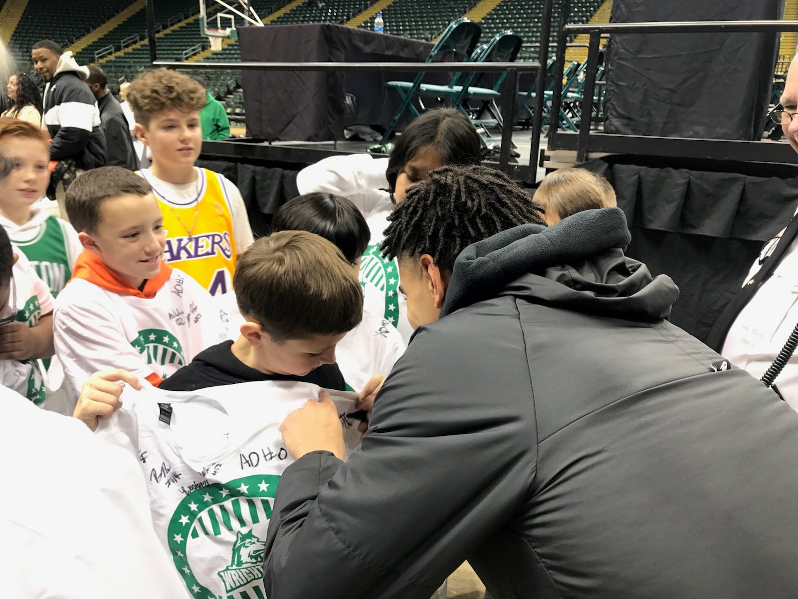 Wright State's Trey Calvin autograph’s a young fan’s shirt after a recent game. Tom Archdeacon/CONTRIBUTED