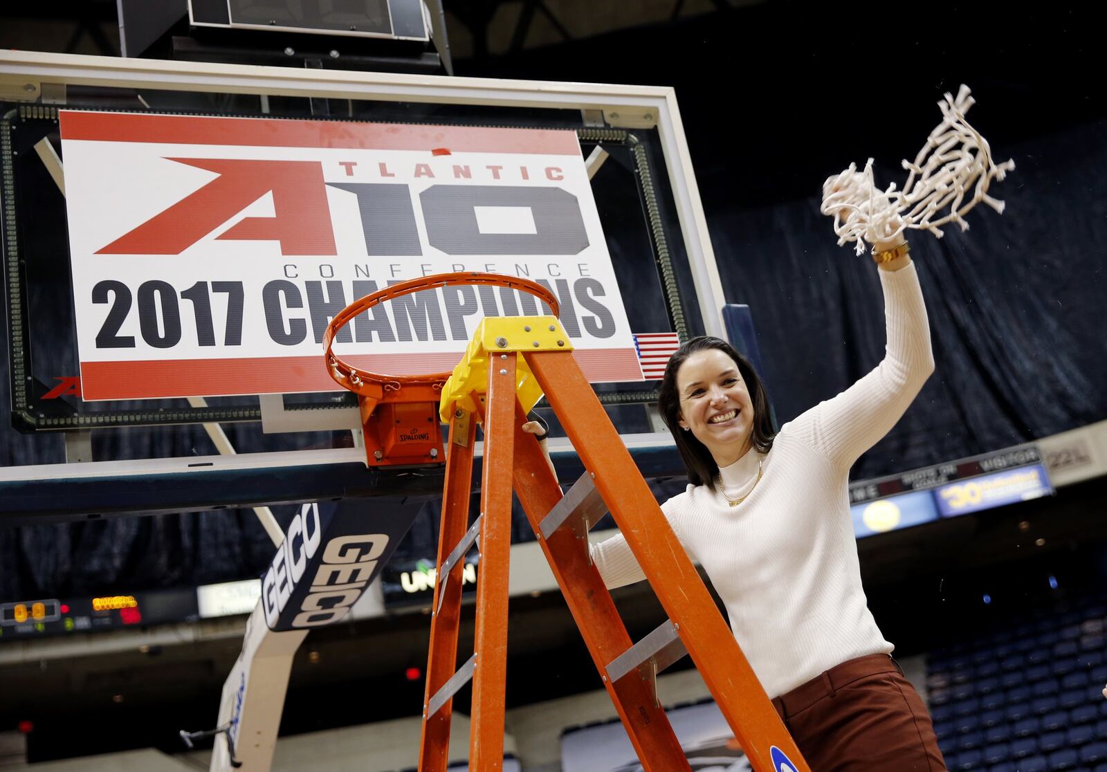 Dayton’s head coach Shauna Green waves a basketball net after defeating Duquesne in the Atlantic 10 women’s NCAA college basketball championship game in Richmond, Va., Sunday, March 5, 2017. (Daniel Sangjib Min /Richmond Times-Dispatch via AP)