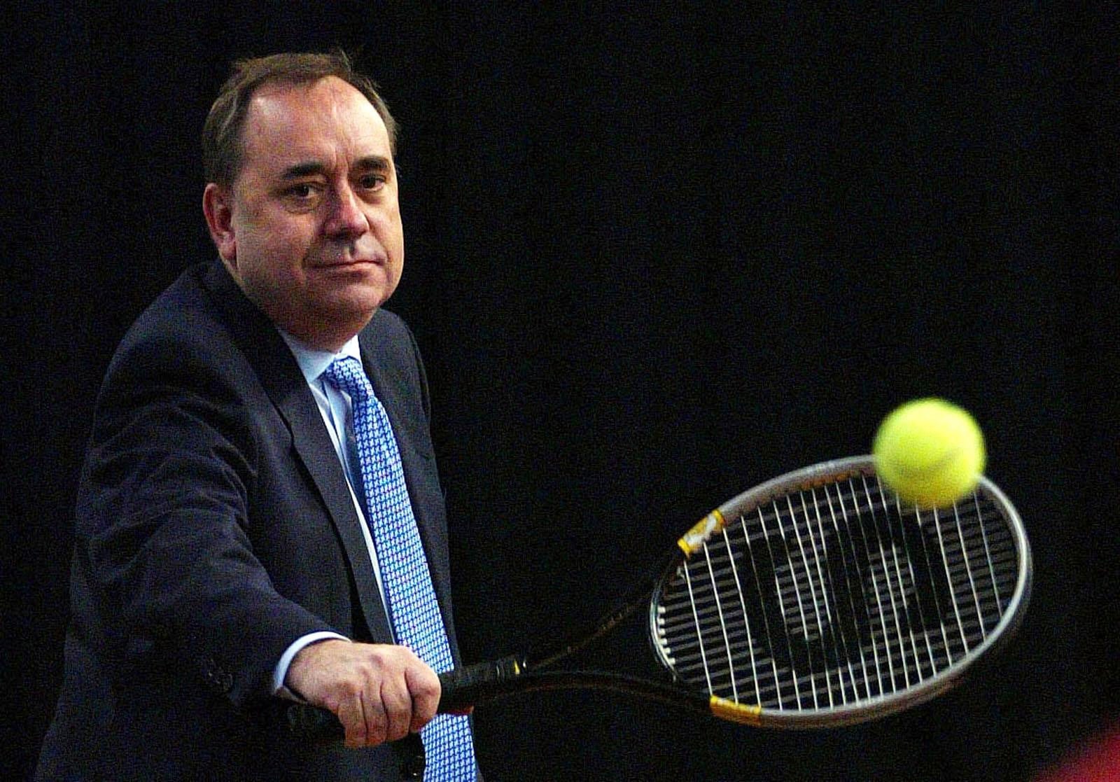 FILE - Alex Salmond takes some tennis shots during a tour of Stirling University's new sports facilities on April 27, 2007. (David Cheskin/PA via AP)