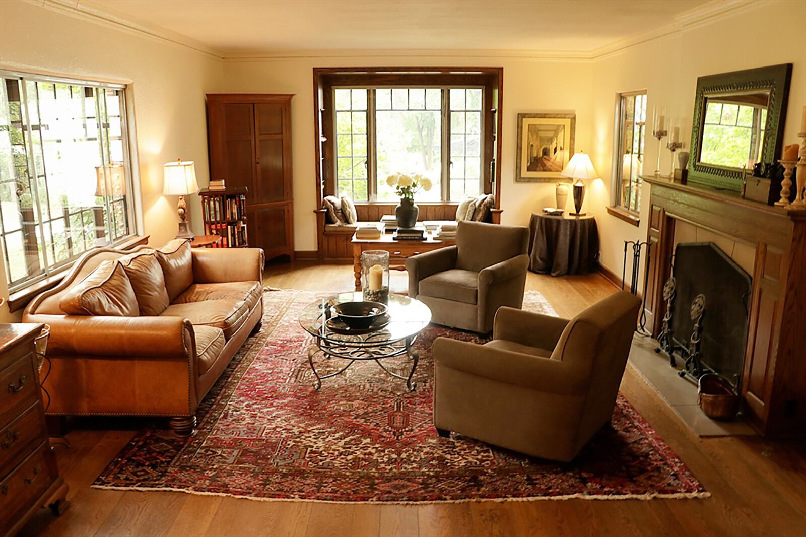 A step down from the foyer and accented by wrought-iron railings is the formal living room with a wood-burning fireplace and a window seat that is flanked by built-in bookcases. CONTRIBUTED PHOTO BY KATHY TYLER