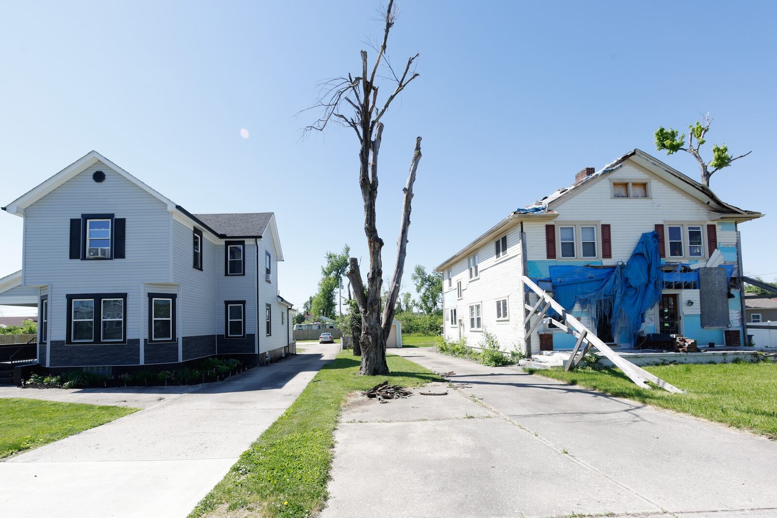 Three years after the 2019 Memorial Day tornadoes, two houses on Hillsdale Avenue, on the Dayton-Harrison Twp. border, show the range of success and struggle in the recovery process.  JIM NOELKER/STAFF