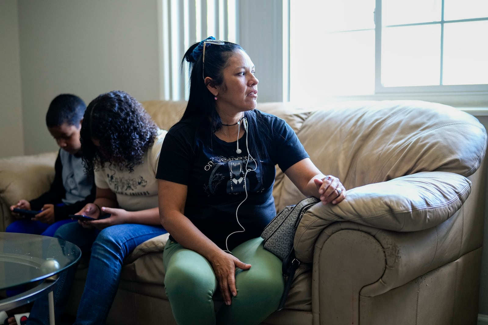 María Ángel Torres talks during an interview at her apartment as her daughter Alisson Ramírez and grandson Dylan Martínez play on their phones Friday, May 18, 2024, in Aurora, Colorado. (AP Photo/Jack Dempsey)