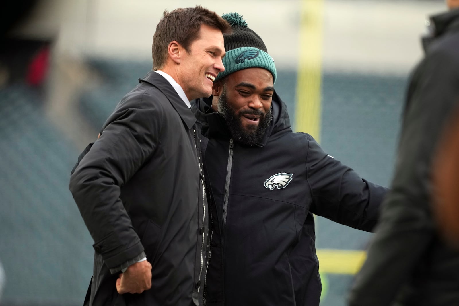 FILE - Former quarterback Tom Brady, left, jokes with Philadelphia Eagles defensive end Brandon Graham before an NFL football game against the Pittsburgh Steelers on Sunday, Dec. 15, 2024, in Philadelphia. (AP Photo/Matt Slocum, File)