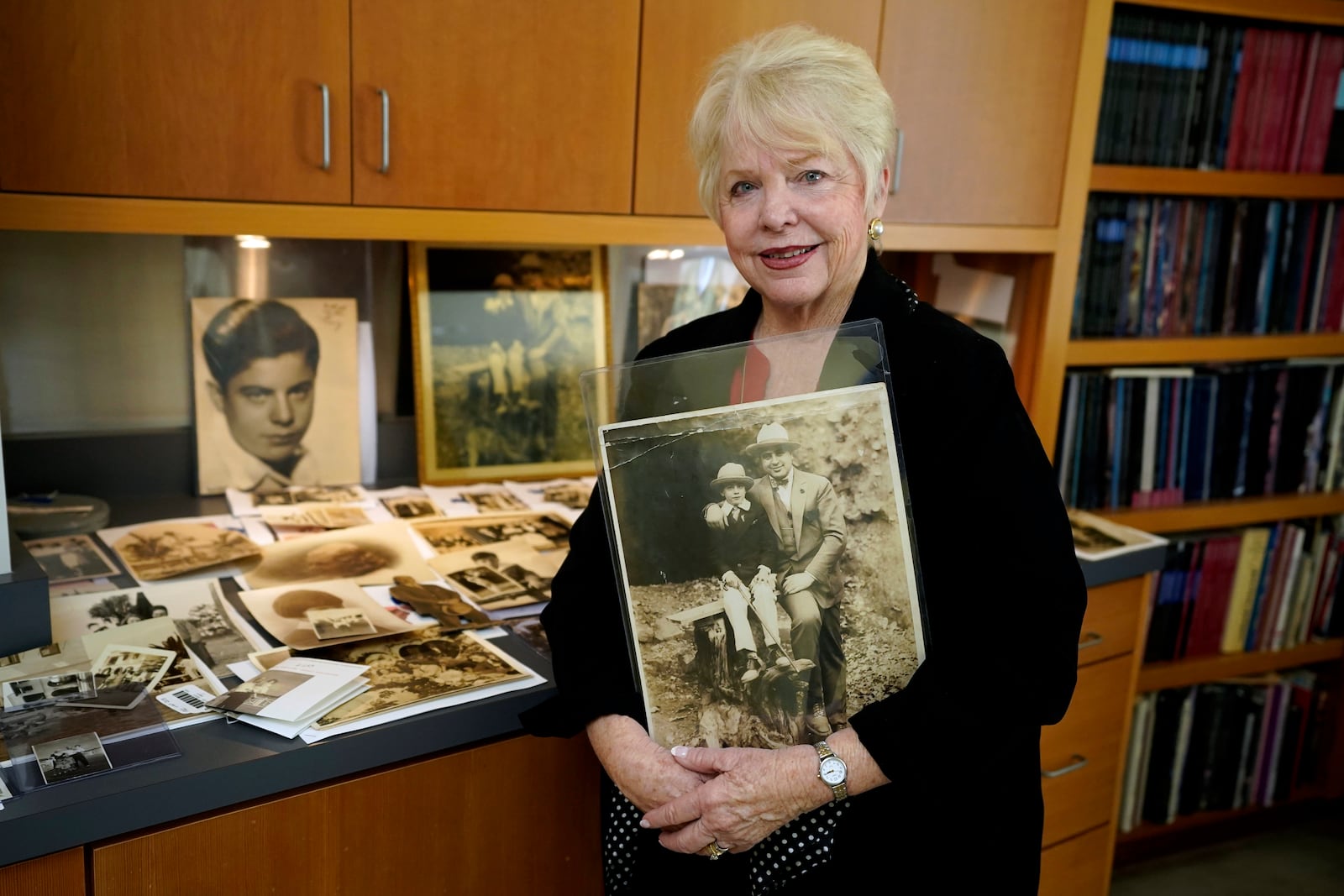 FILE - Diane Capone holds a copy of a photograph of her father, Albert "Sonny" Capone as a young boy and her grandfather Al Capone on display at Witherell's Auction House in Sacramento, Calif., Wednesday, Aug. 25, 2021. (AP Photo/Rich Pedroncelli, File)