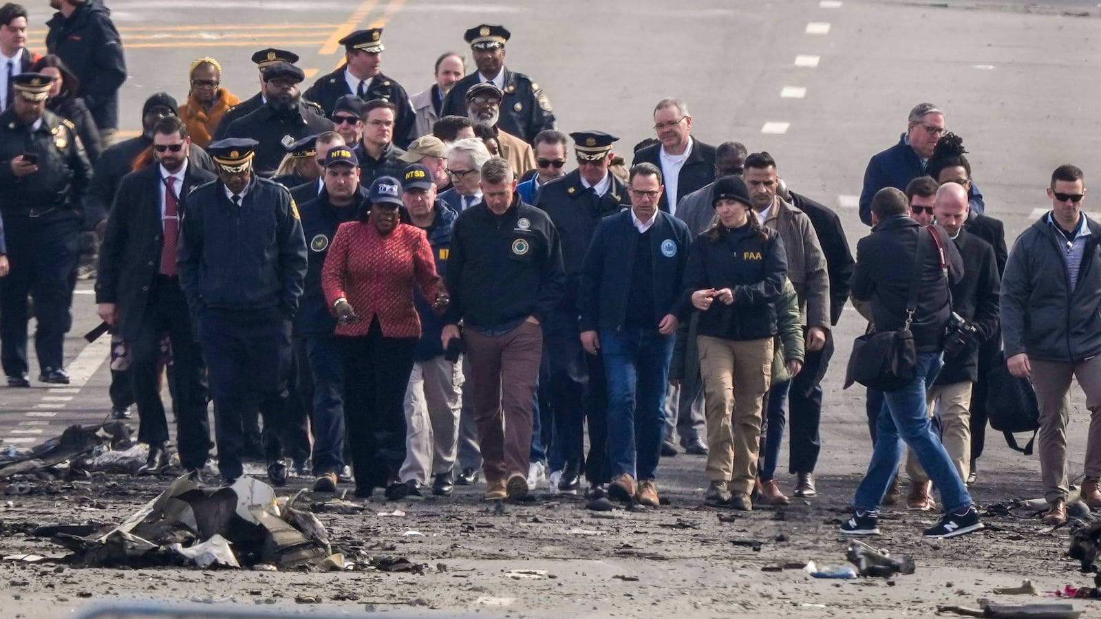 Pennsylvania Gov. Josh Shapiro, Philadelphia Mayor Cherelle Parker and other officials view the aftermath of a fatal small plane crashed in Philadelphia, Monday, Feb. 3, 2025. (AP Photo/Matt Rourke)