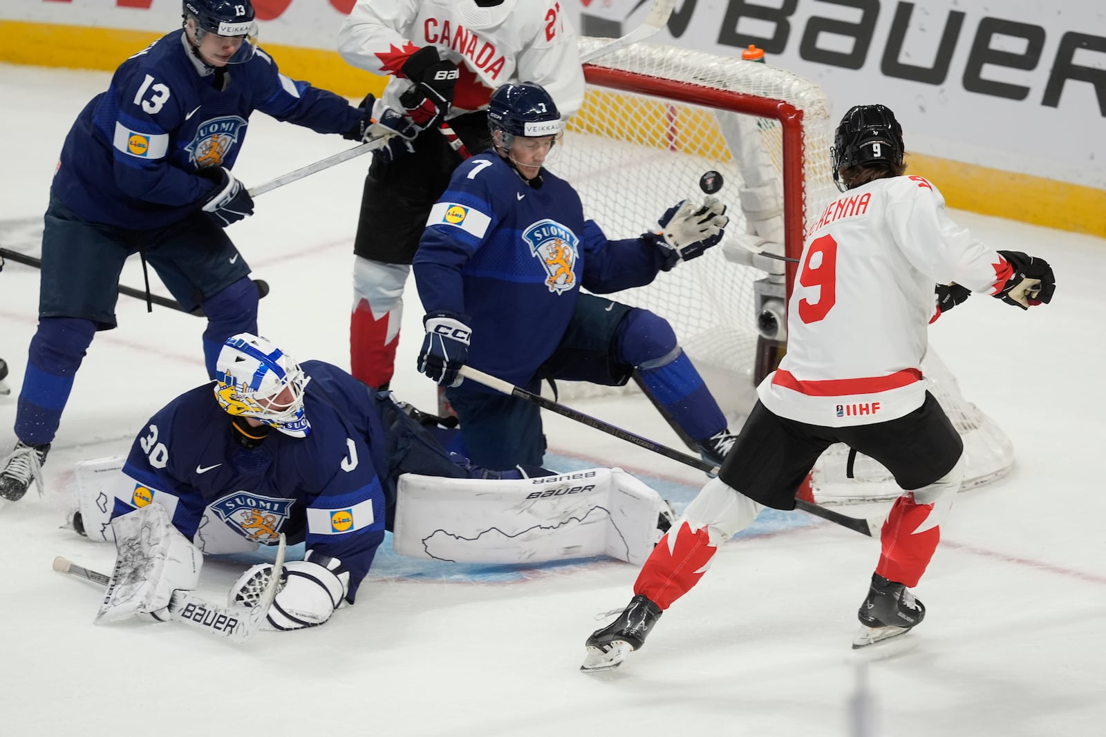 Canada forward Gavin McKenna (9) scores on Finland goaltender Petteri Rimpinen (30), as defensemen Veeti Vaisanen (13) and Daniel Nieminen (7) try to cover the net during first period IIHF World Junior Hockey Championship tournament action, Thursday, Dec. 26, 2024, in Ottawa. (Adrian Wyld/The Canadian Press via AP)