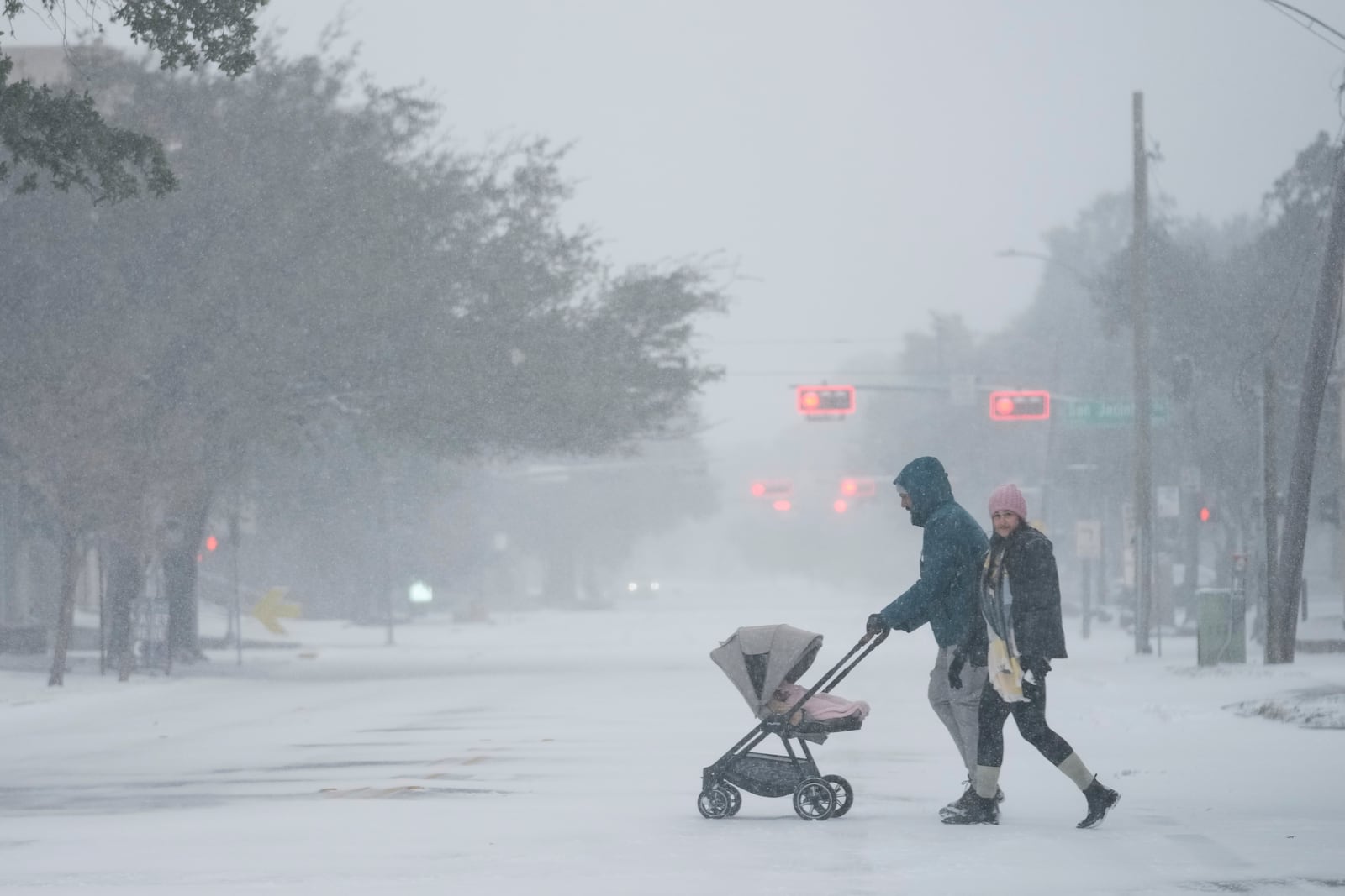 People take a walk in the neighborhood Tuesday, Jan. 21, 2025, in Houston. (AP Photo/Ashley Landis)