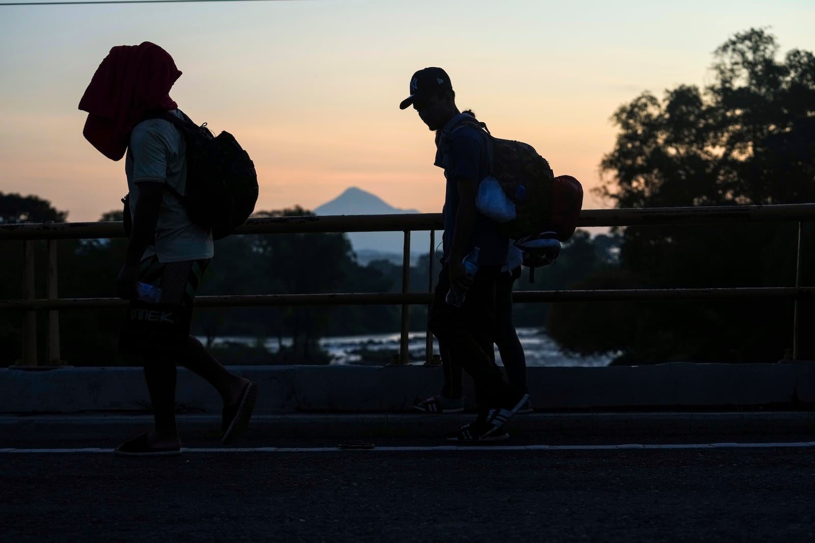 Backdropped the Tajumulco volcano, migrants walk along the Huixtla highway, in southern Mexico, Wednesday, Nov. 6, 2024, hoping to reach the country's northern border and ultimately the United States. (AP Photo/Moises Castillo)