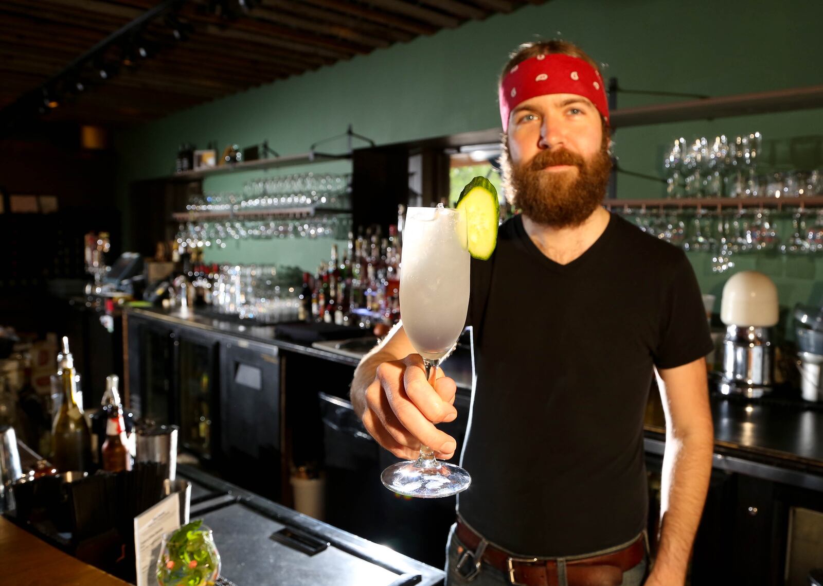 Wheat Penny Bartender Brock McKibben with the summer cocktail Autopilot. Made with Hendrick's Gin, House Made Cucumber Mint Basil Syrup, Creme De Violette, Fresh Squeezed Lemon Juice, Cucumber Garnish. JIM WITMER/STAFF