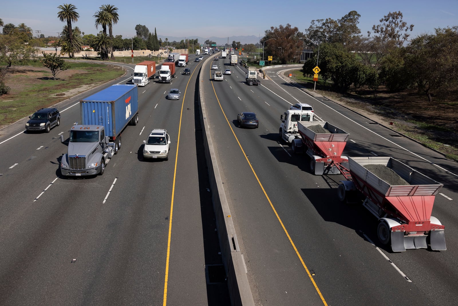 A picture shot from a bridge overlooking the 710 highway shows the traffic going in and out of the Ports of Los Angeles and Long Beach, Monday, March 10, 2025, in Long Beach, Calif. (AP Photo/Etienne Laurent)