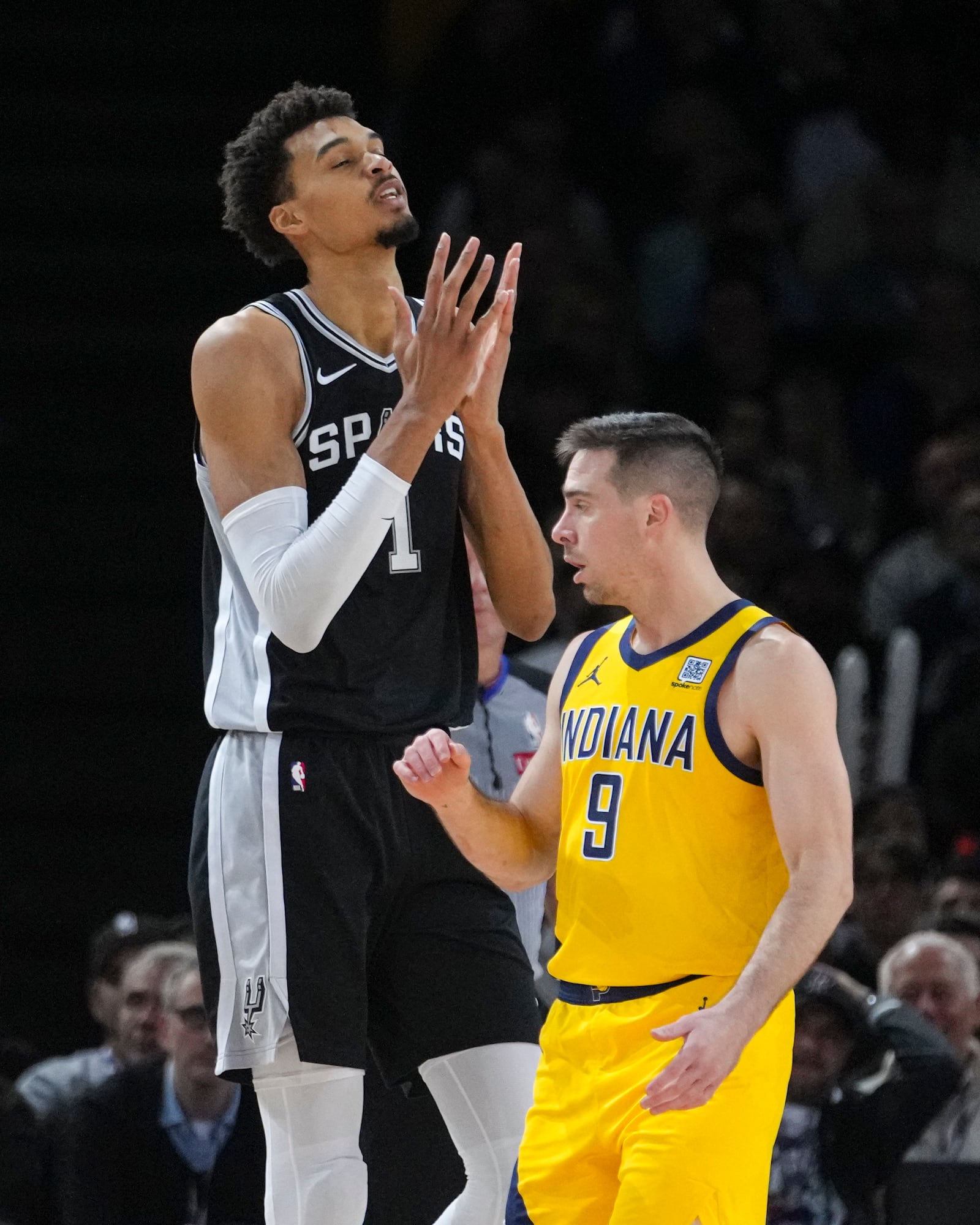 Indiana Pacers guard T.J. McConnell (9) and San Antonio Spurs center Victor Wembanyama (1) react after a pacers basket during the second half of a Paris Games 2025 NBA basketball game in Paris, Saturday, Jan. 25, 2025. (AP Photo/Thibault Camus)