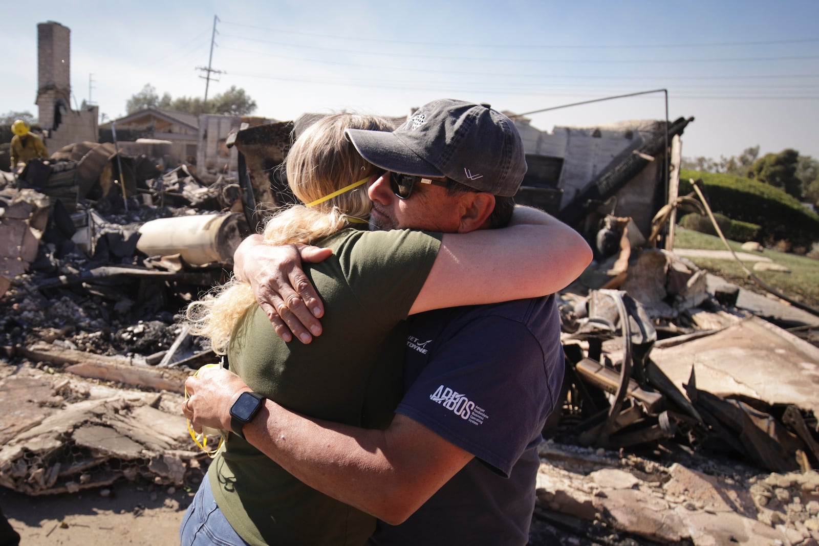 Kelly Barton, left, is hugged by a family friend after arriving at her parents' fire-ravaged property in the aftermath of the Mountain Fire, Thursday, Nov. 7, 2024, in Camarillo, Calif. (AP Photo/Ethan Swope)