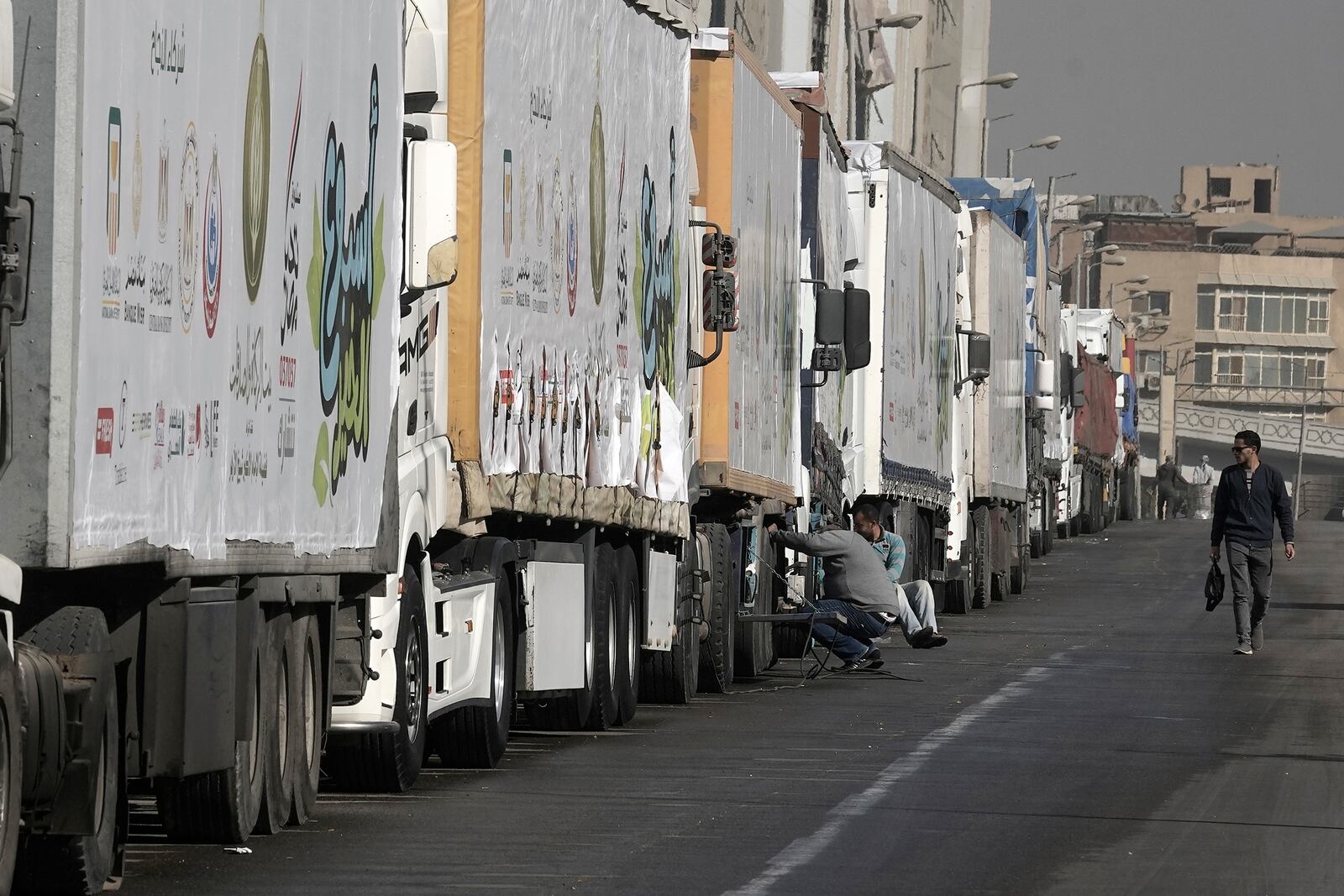 Truck drivers of humanitarian aid wait at a parking point in Cairo, Egypt, on their way to cross the Rafah border crossing between Egypt and the Gaza Strip, Sunday, Jan. 26, 2025. (AP Photo/Amr Nabil)