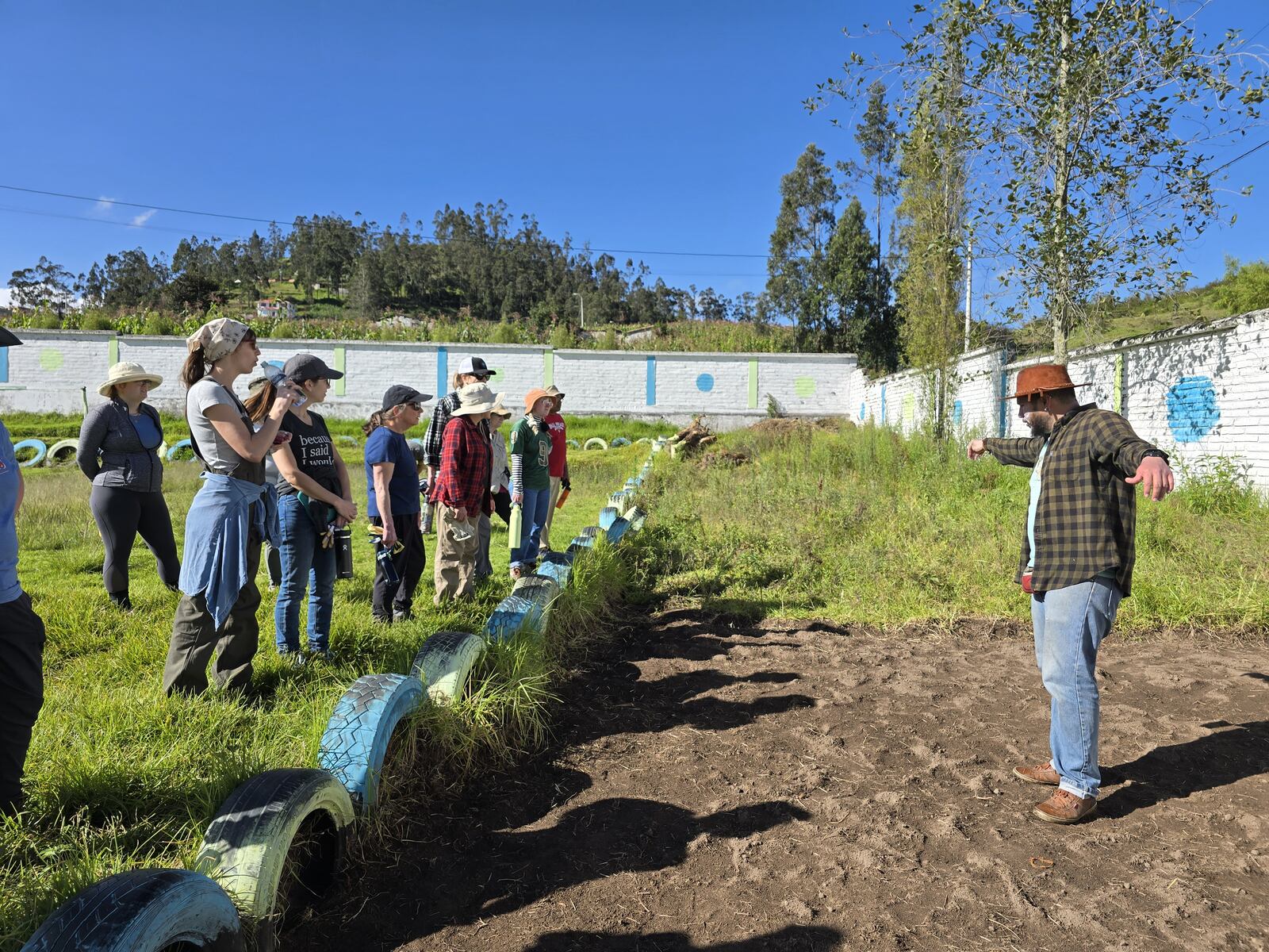 Getting instructions from the leader on how to remove the grass and weeds from the garden in the background. CONTRIBUTED