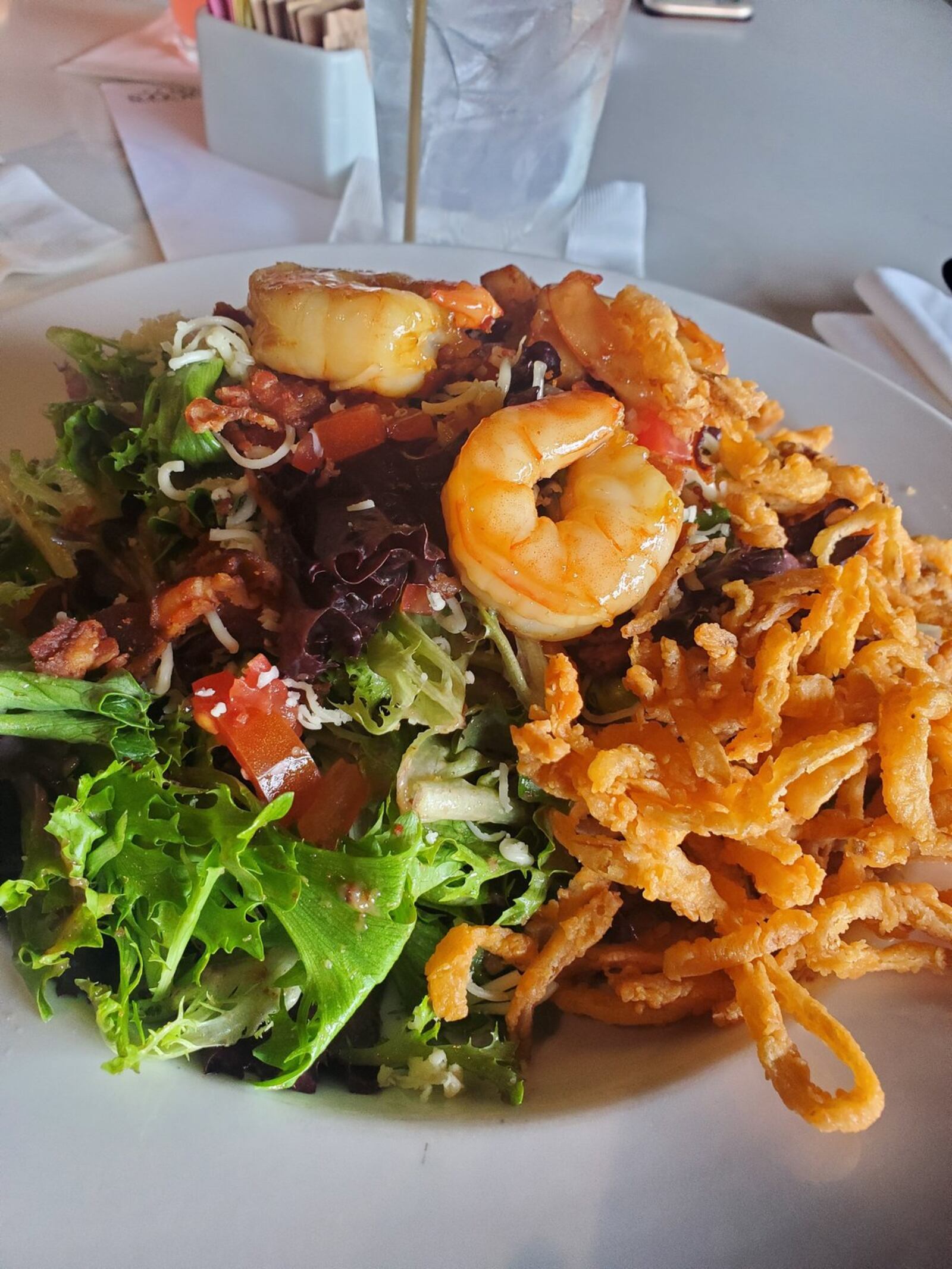 Coco’s Bistro’s Bourbon Street Salad with mixed greens, bourbon-glazed shrimp, Applewood smoked bacon, fontana, toasted pecan vinaigrette and spicy onion straws. CONTRIBUTED