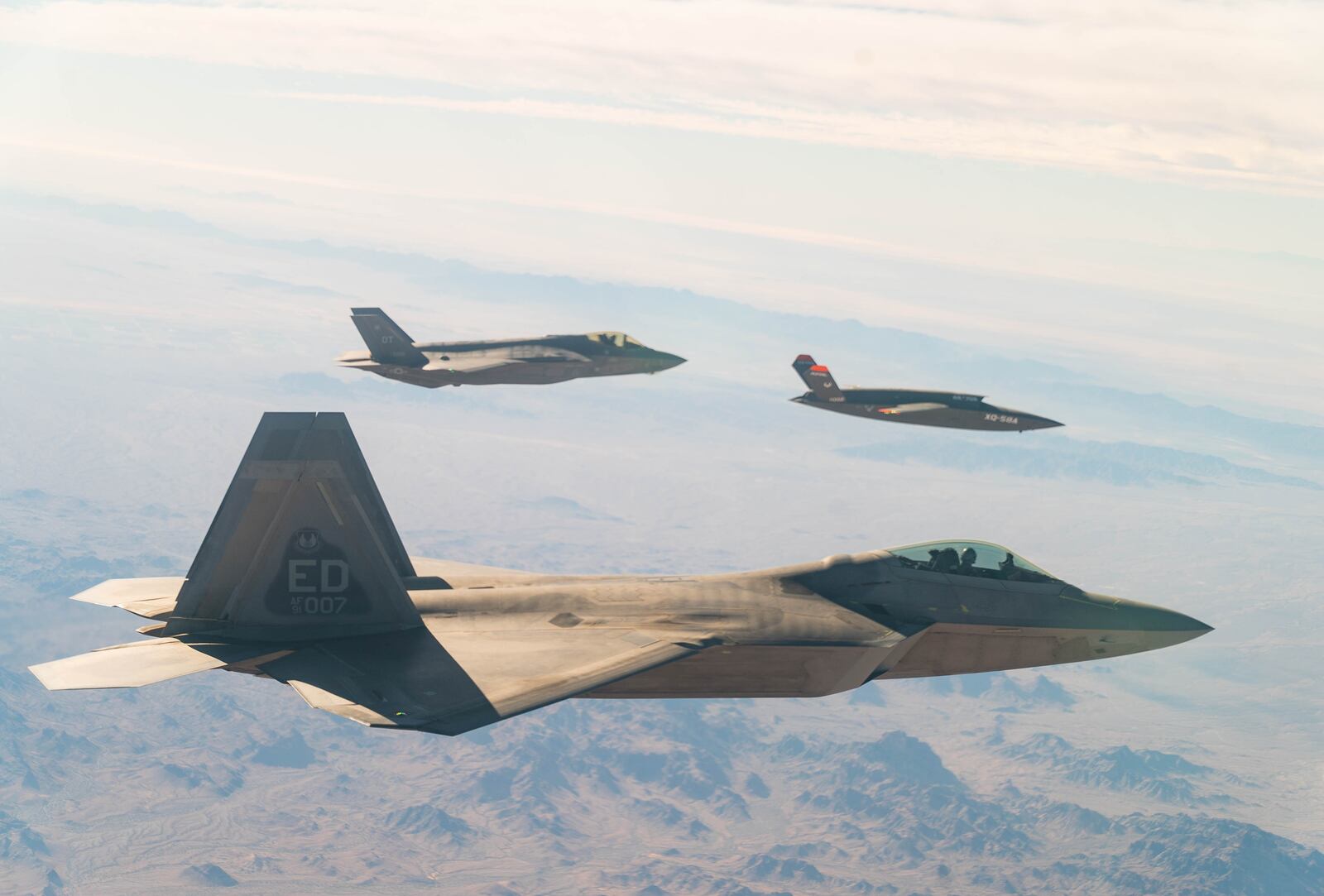 U.S. Air Force F-22 Raptor and F-35A Lightning II fly in formation with the XQ-58A Valkyrie low-cost unmanned aerial vehicle over the U.S. Army Yuma Proving Ground testing range, Ariz., during a series of tests Dec. 9, 2020. This integrated test follows a series of gatewayONE ground tests that began during the inaugural Department of the Air Force on-ramp last year in December. (U.S. Air Force photo by Tech. Sgt. James Cason)