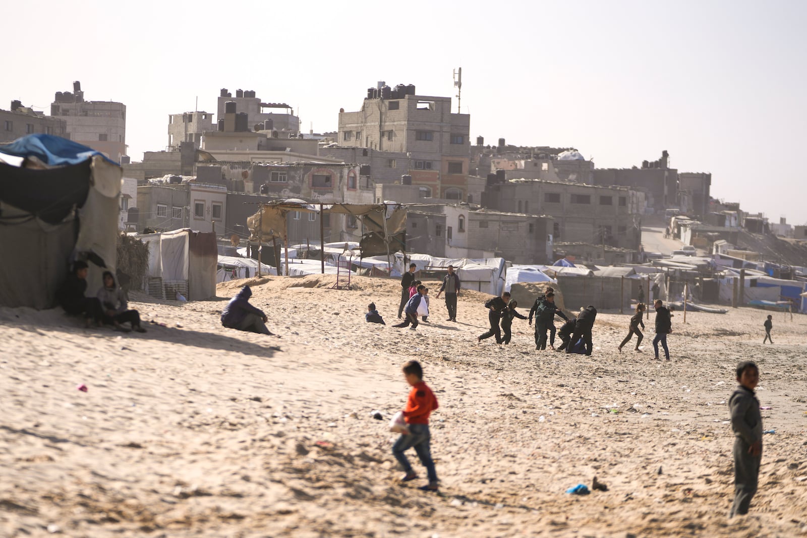 Children play on the sand in a camp for internally displaced Palestinians at the beachfront in Deir al-Balah, central Gaza Strip, Friday, Dec. 27, 2024. (AP Photo/Abdel Kareem Hana)