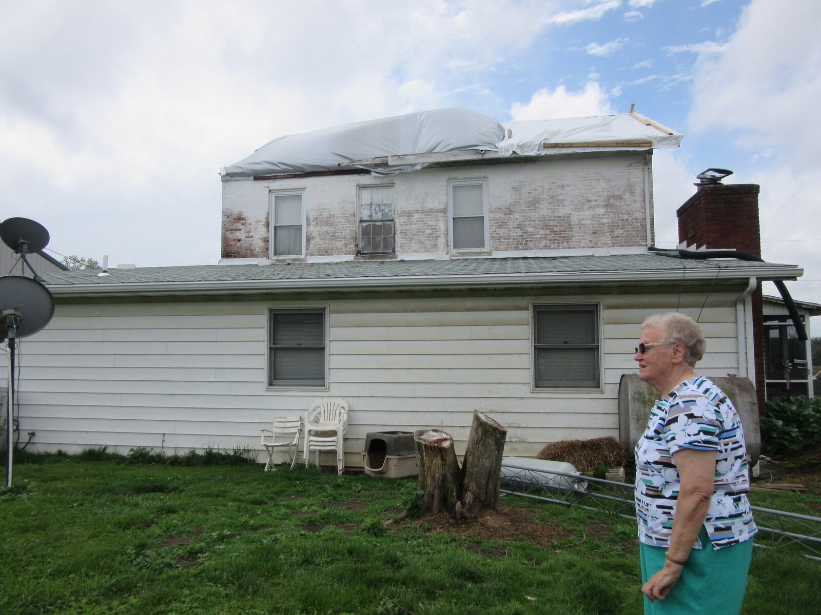 Mary Ann Barr surveys damage from Monday’s tornado at this farm she and her husband, James Barr own at 1045 Ludlow Road in Beavercreek Township. The farm was hit by last Monday’s tornado and also by a tornado on April 3, 2018. The latest tornado tore off their home’s roof, which they had had replaced after last year’s tornado, and damaged two other buildings, including one that was replaced after being damaged in last year’s tornado. PHOTO by Lynn Hulsey