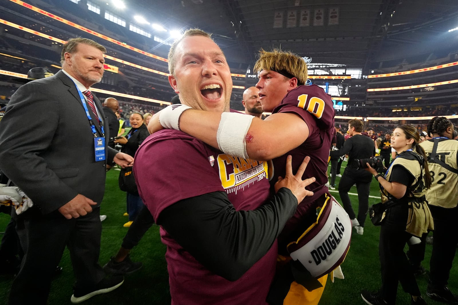 Ariona State head coach Kenny Dillingham, left, and quarterback Sam Leavitt, right, celebrate after the team's win in the Big 12 Conference championship NCAA college football game against Iowa State, in Arlington, Texas, Saturday Dec. 7, 2024. (AP Photo/Julio Cortez)