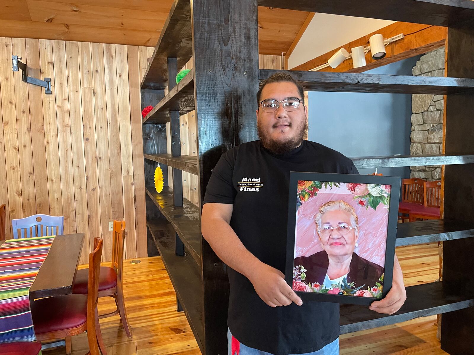 Mami Fina's is named in honor of owner Jorge Jimenez's grandmother. Jimenez is seen here with a photo of his grandmother. NATALIE JONES/STAFF