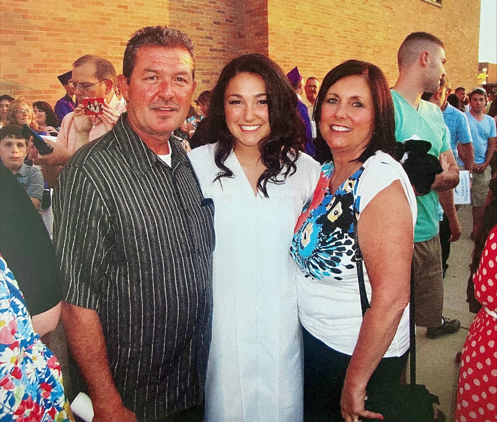 Kara Hamby (center) at her graduation from Vandalia Butler High school in 2012 with her parents Keith and Sharon Hamby. Kara said she knew then she wanted to work in government communications. CONTRIBUTED