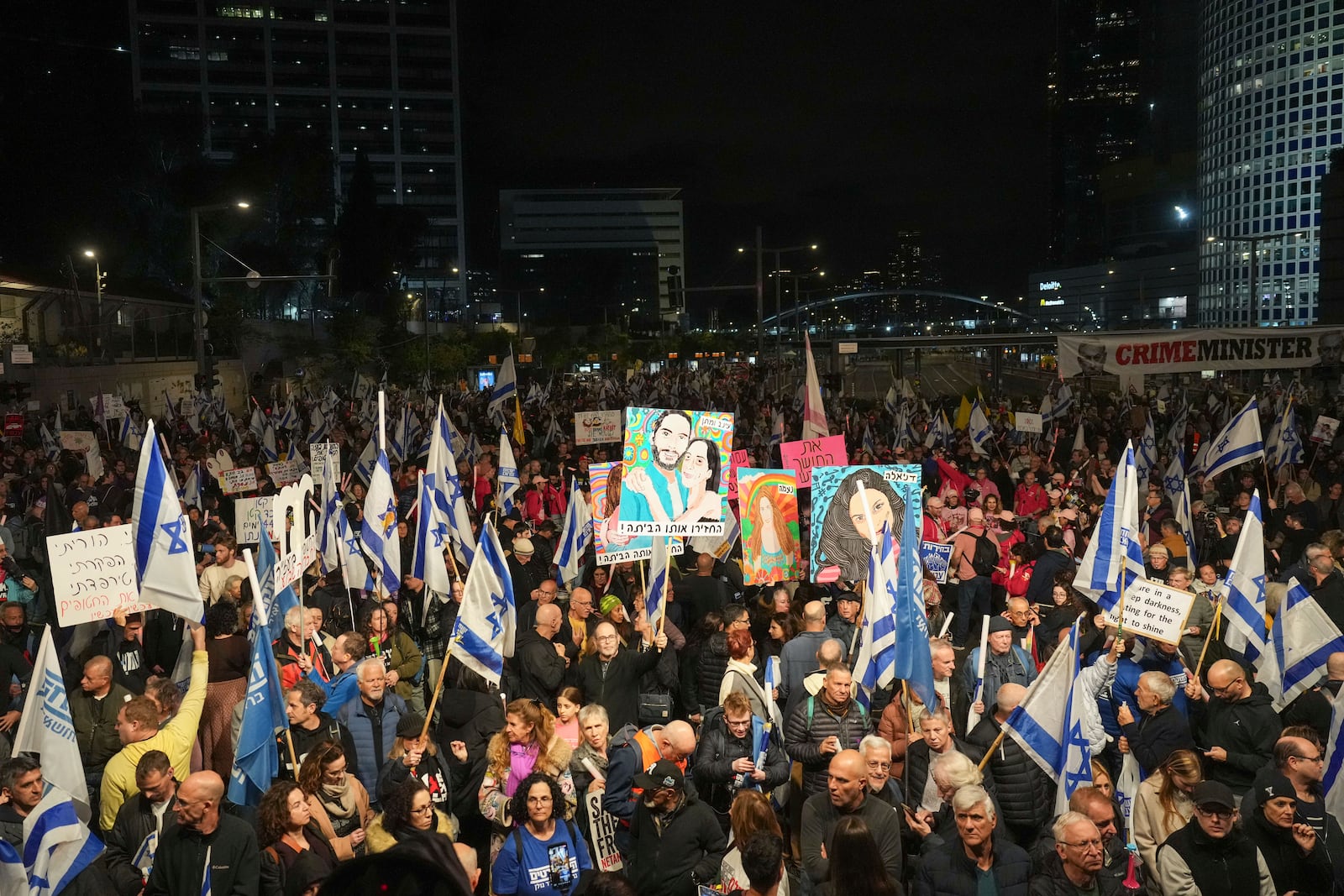 Israelis protest against Prime Minister Benjamin Netanyahu's government and call for the release of hostages held in the Gaza Strip by the Hamas militant group, in Tel Aviv, Israel, Saturday, Dec. 28, 2024. (AP Photo/Ariel Schalit)