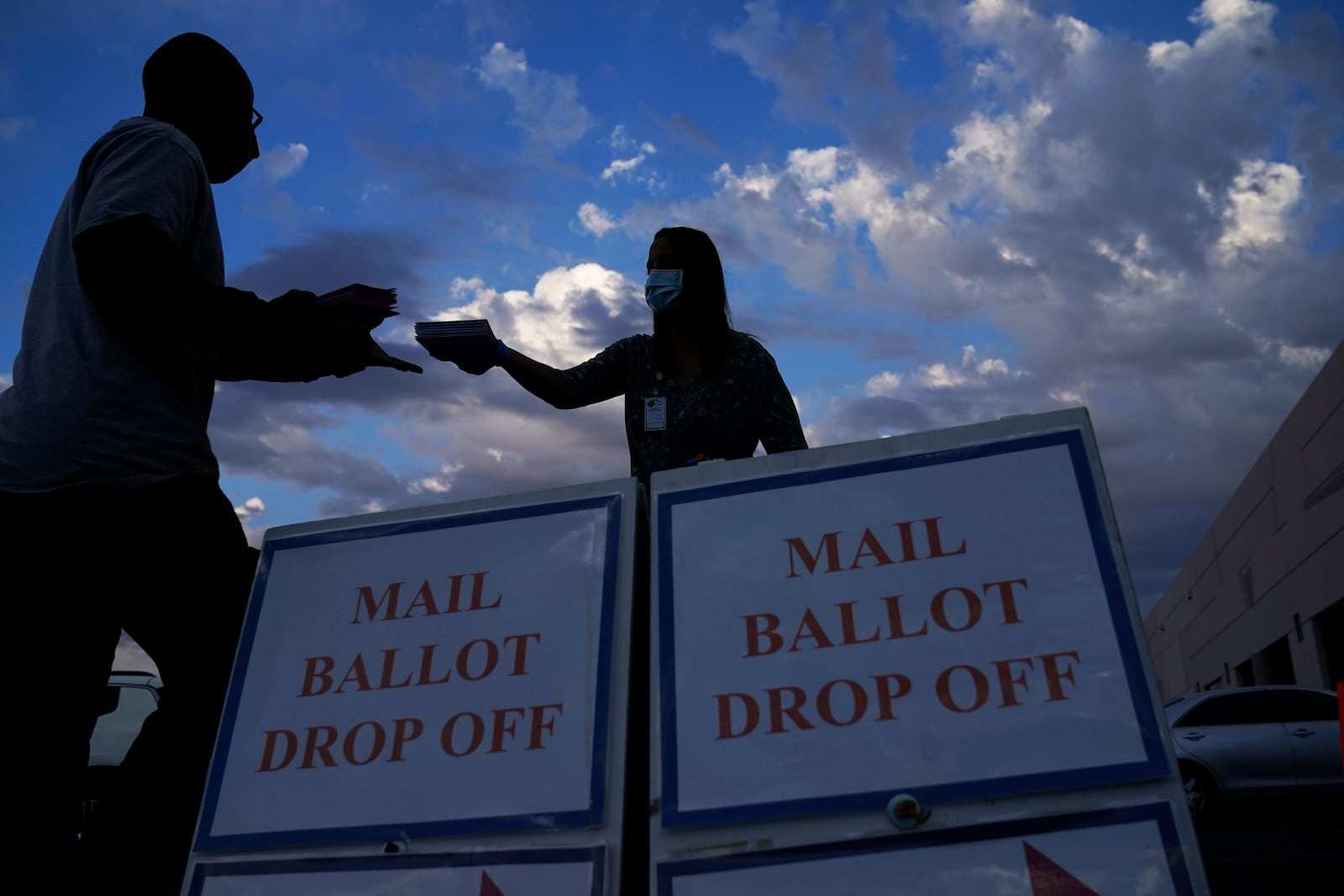 FILE - A county worker collects a mail-in ballots in a drive-thru mail-in ballot drop off area at the Clark County Election Department, Monday, Nov. 2, 2020, in Las Vegas. (AP Photo/John Locher, File)