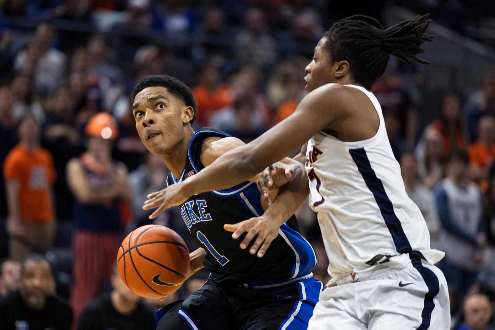 Duke guard Caleb Foster (1) defends the ball from Virginia guard Dai Dai Ames during the second half of an NCAA college basketball game, Monday, Feb. 17, 2025, in Charlottesville, Va. (AP Photo/Mike Kropf)