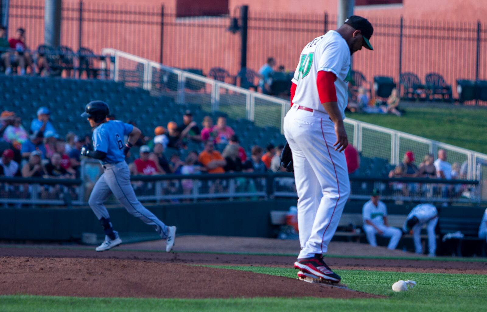 Reds reliever Michael Feliz walks off the mound as Lake County's Joe Naranjo rounds third base after homering to right Tuesday night at Day Air Ballpark. Feliz was making a rehab appearance with the Dragons and allowed four runs in one inning. Jeff Gilbert/CONTRIBUTED