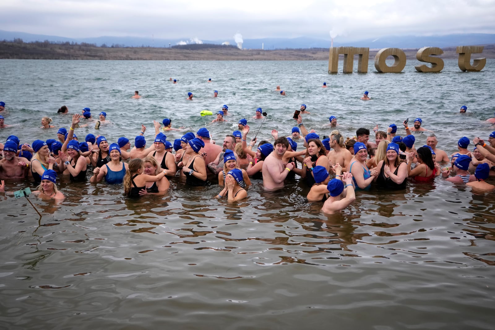 Some of 2461 polar swimmers wait in the water to set a world record for the largest polar bear dip at a lake in Most, Czech Republic, Saturday, March 1, 2025. (AP Photo/Petr David Josek)