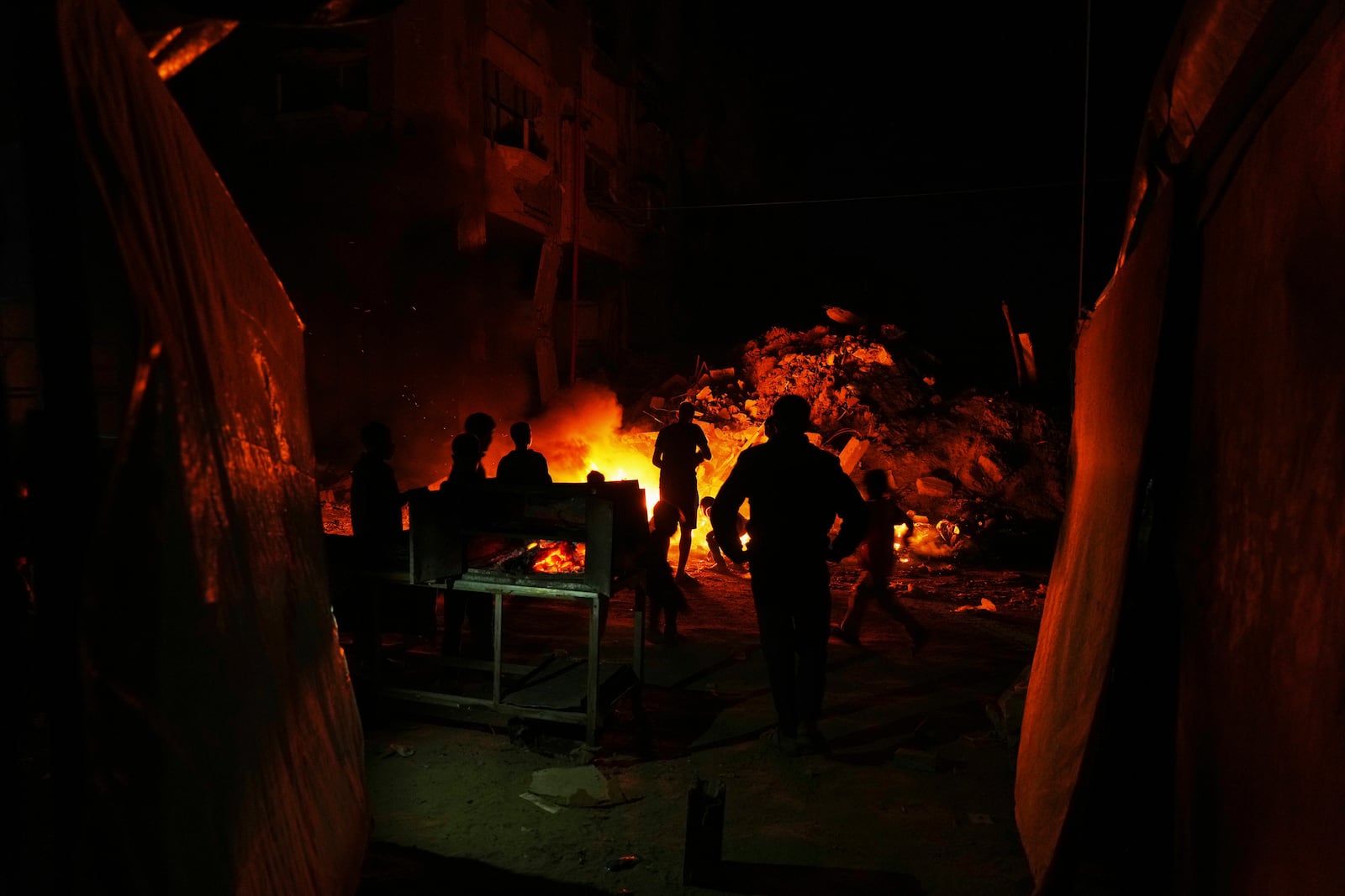 Displaced Palestinians burn waste in central Gaza Strip on Friday, March 14, 2025. (AP Photo/Jehad Alshrafi)