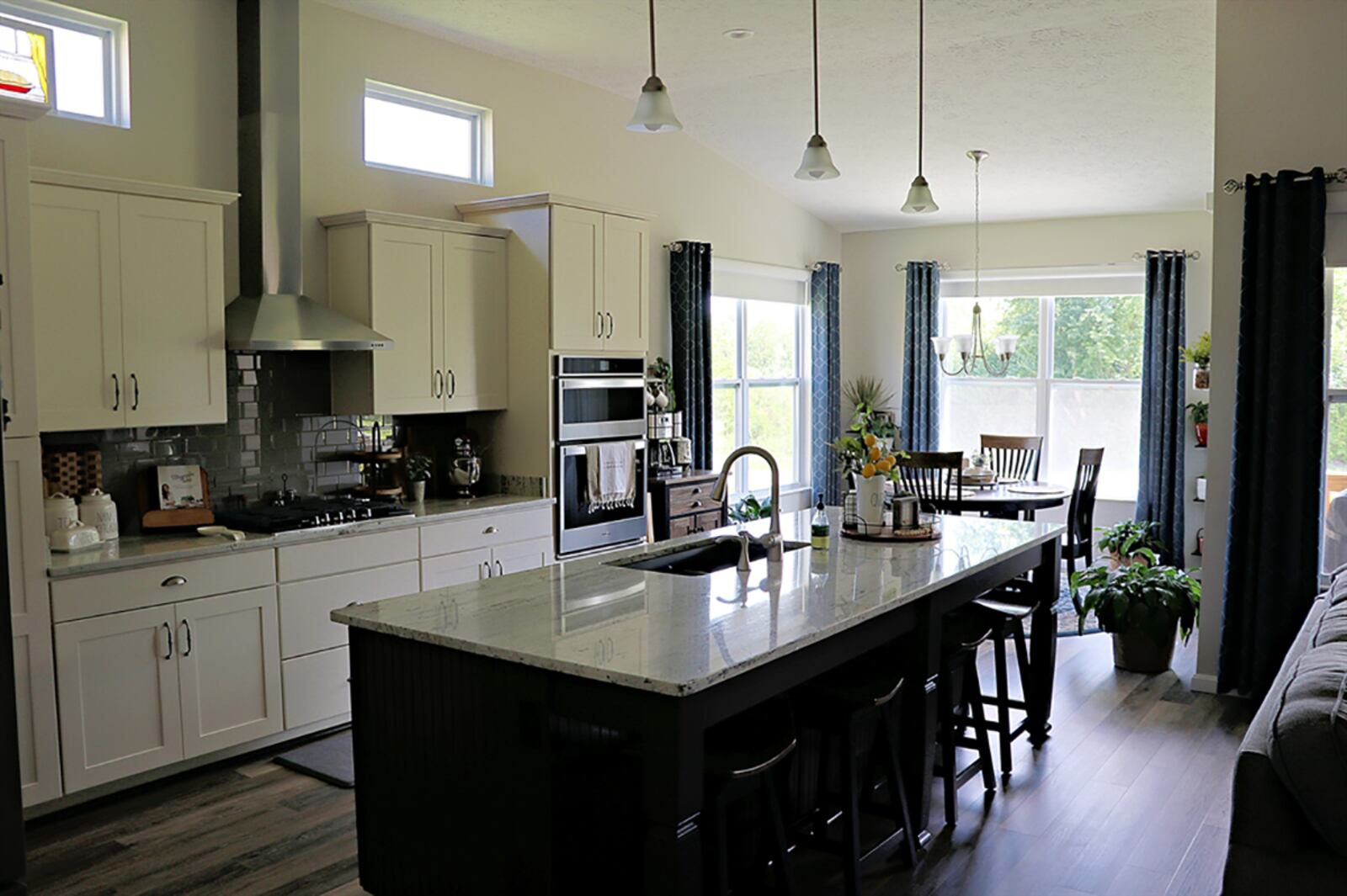 A large island is the focal point of the kitchen and offers table setting for four near the great room. A double sink, storage and a dishwasher are built into the kitchen side of the island, which has a granite countertop. CONTRIBUTED PHOTO BY KATHY TYLER