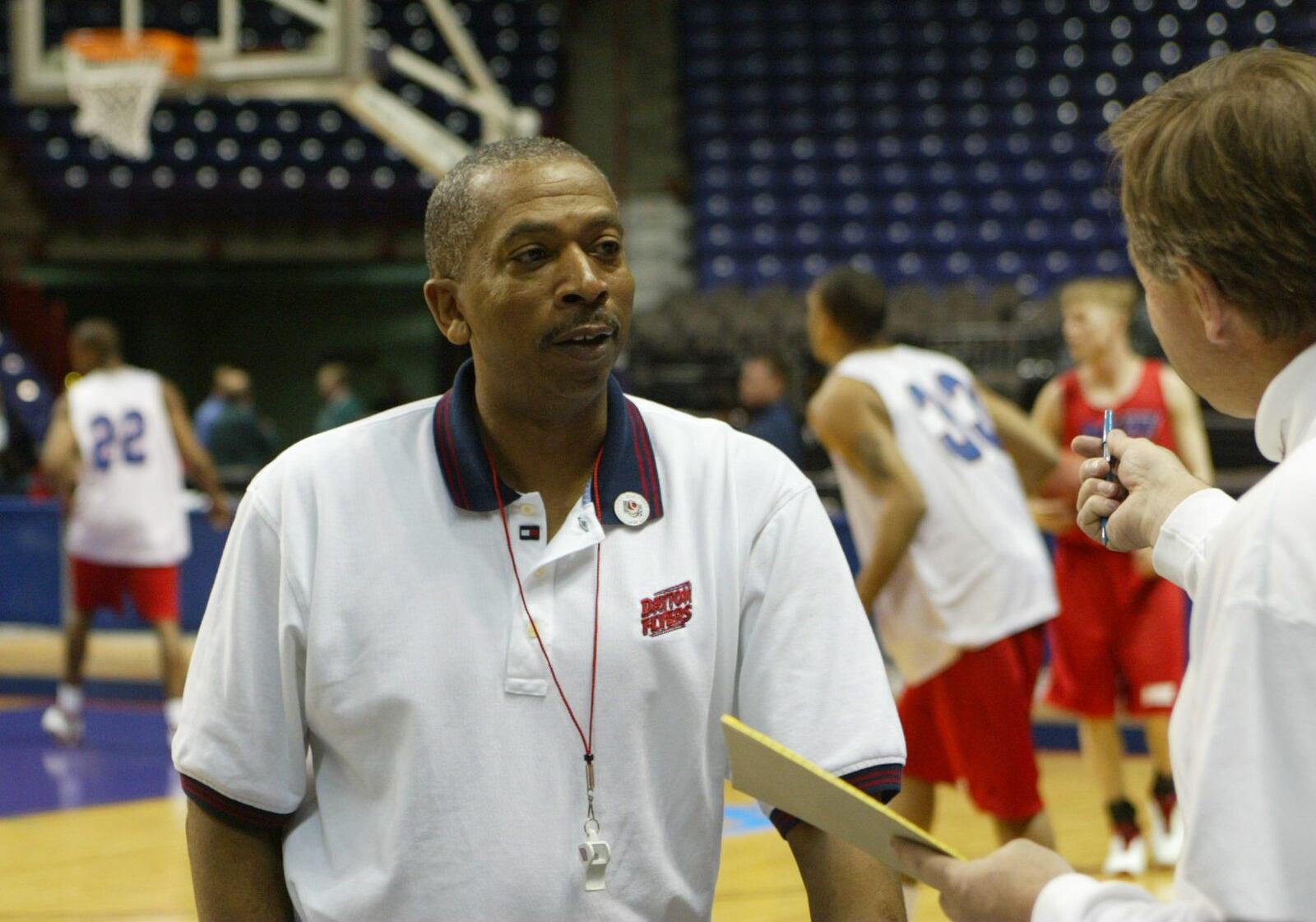 Oliver Purnell, the head coach of the Dayton Flyers, fills in Bob Wenzel, a CBS TV announcer, on the Dayton Flyers as they practice in the Spokane Arena before the NCAA tournament in 2003.